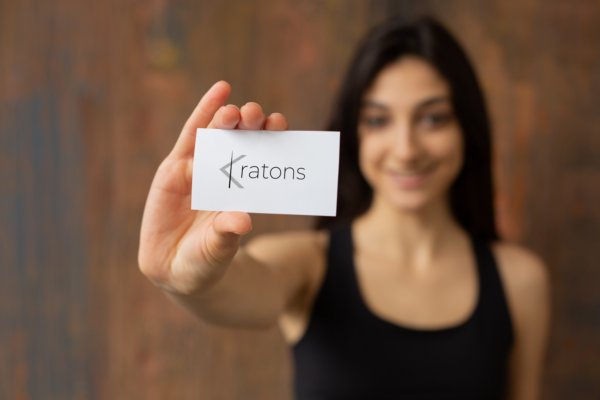 Young lady showing a business card of Kratons