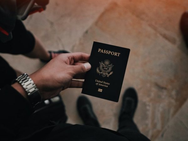 Man's hand holding a passport