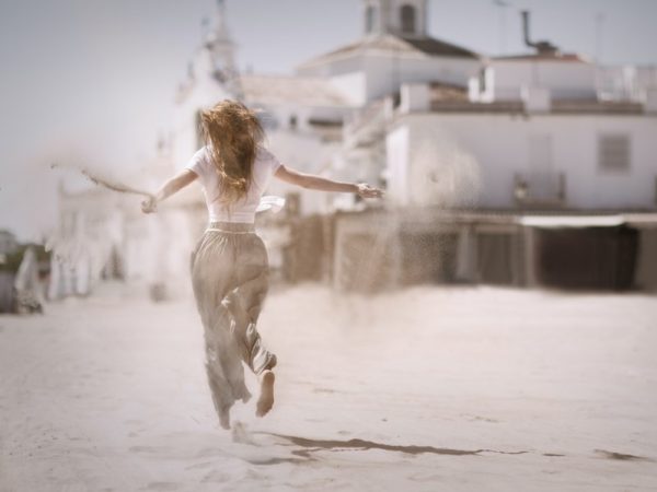 Young woman running a throwing sand from her hands