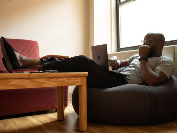 Man resting in the couch while looking at his laptop