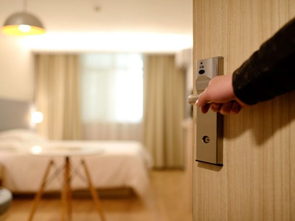 Hand opening the door of a hotel room